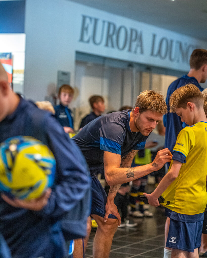 dreng får autografer på fodboldcamp
